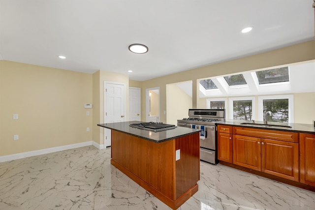 kitchen featuring baseboards, a sink, stainless steel appliances, marble finish floor, and a center island