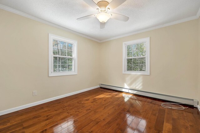 empty room featuring baseboard heating, a textured ceiling, baseboards, and wood-type flooring