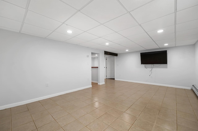 finished basement featuring a drop ceiling, recessed lighting, and baseboards