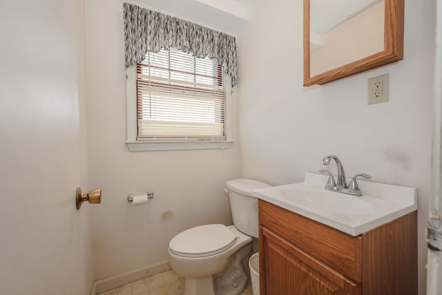 bathroom with vanity, toilet, and baseboards