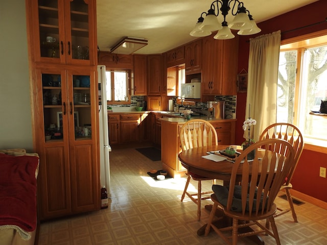 dining room with a notable chandelier, baseboards, and light floors