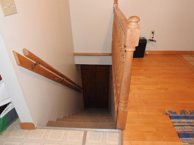 stairway with baseboards and wood finished floors