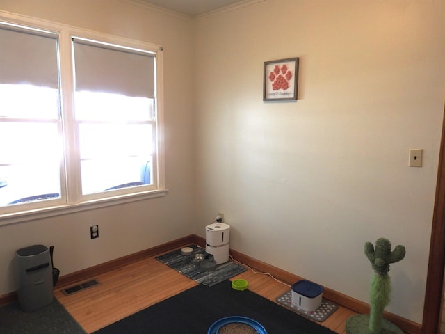 unfurnished room featuring visible vents, baseboards, and wood finished floors