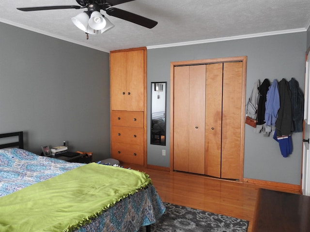 bedroom with a textured ceiling, a ceiling fan, wood finished floors, and ornamental molding