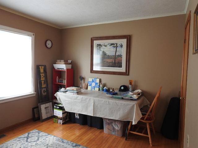 dining room with crown molding, wood finished floors, and visible vents