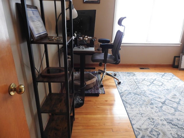 office space with visible vents, baseboards, and wood finished floors