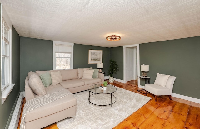 living area with wood finished floors, baseboards, and a baseboard radiator