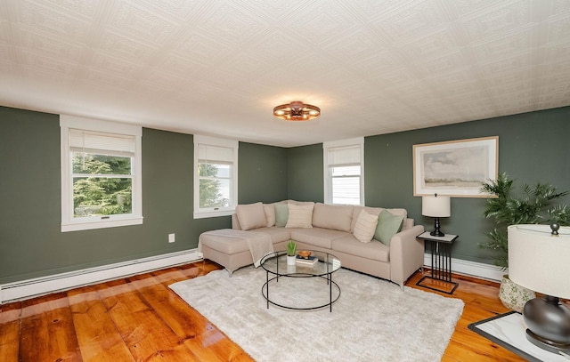 living area with baseboards, baseboard heating, and wood finished floors