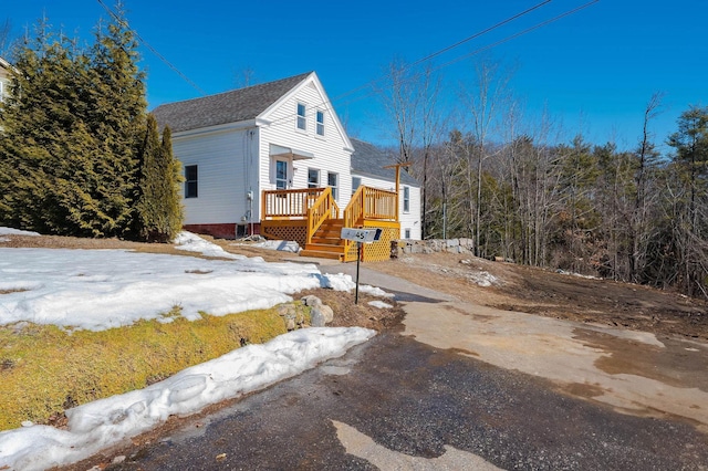 view of side of home with a deck and driveway