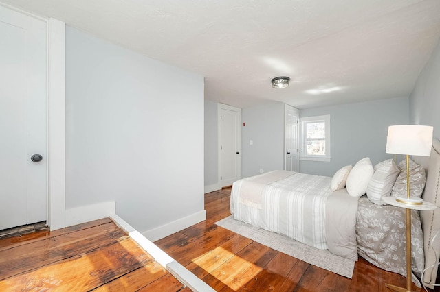 bedroom featuring hardwood / wood-style flooring and baseboards