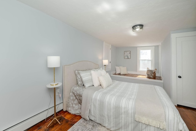 bedroom featuring wood finished floors and a baseboard radiator