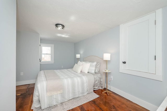 bedroom featuring baseboards and wood finished floors