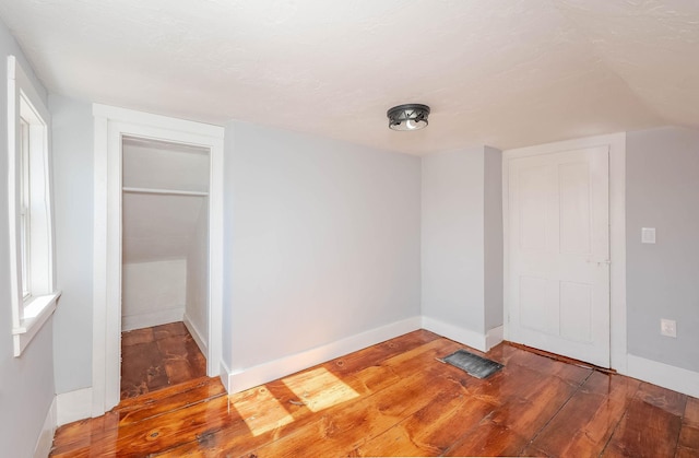 unfurnished bedroom with baseboards and wood-type flooring