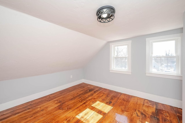 bonus room featuring baseboards, lofted ceiling, and hardwood / wood-style floors