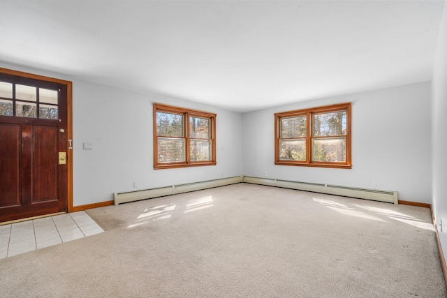 tiled foyer entrance featuring baseboard heating, baseboards, and carpet