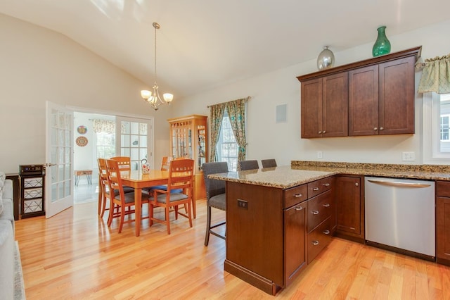 kitchen with a kitchen breakfast bar, stainless steel dishwasher, french doors, light wood-style floors, and vaulted ceiling