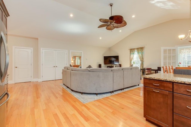 living area featuring light wood finished floors, recessed lighting, a healthy amount of sunlight, and lofted ceiling