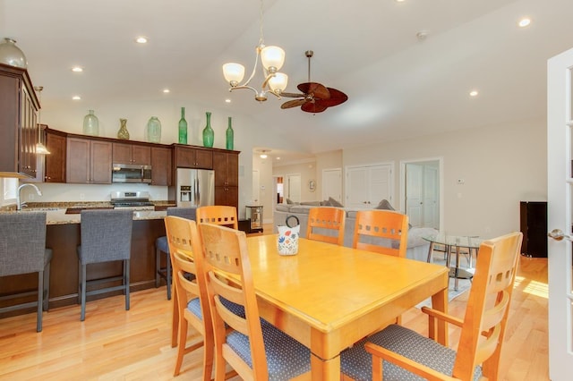 dining room featuring recessed lighting, light wood-type flooring, and vaulted ceiling