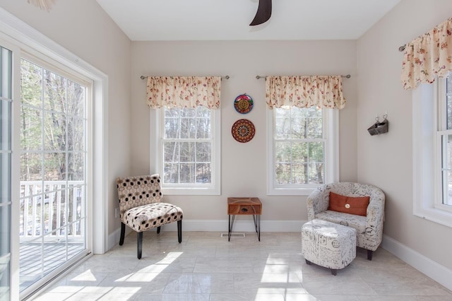 sitting room featuring ceiling fan and baseboards