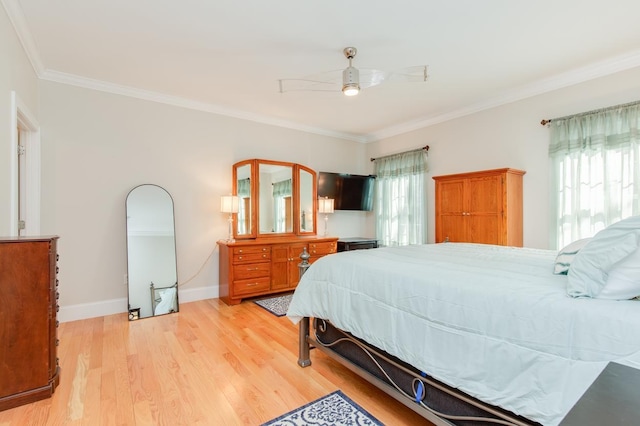 bedroom featuring baseboards, crown molding, light wood-style floors, and a ceiling fan