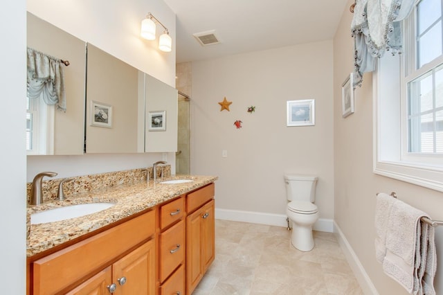 bathroom with a sink, visible vents, toilet, and double vanity