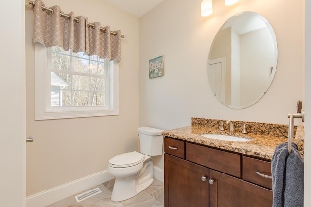 bathroom featuring vanity, toilet, baseboards, and visible vents