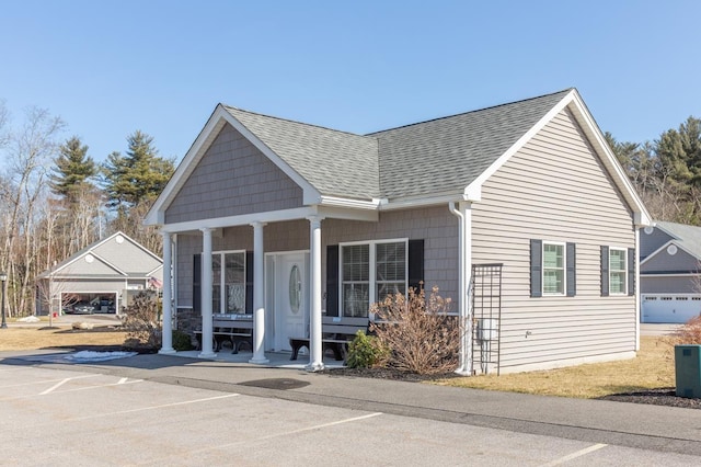 view of front facade with covered porch and roof with shingles