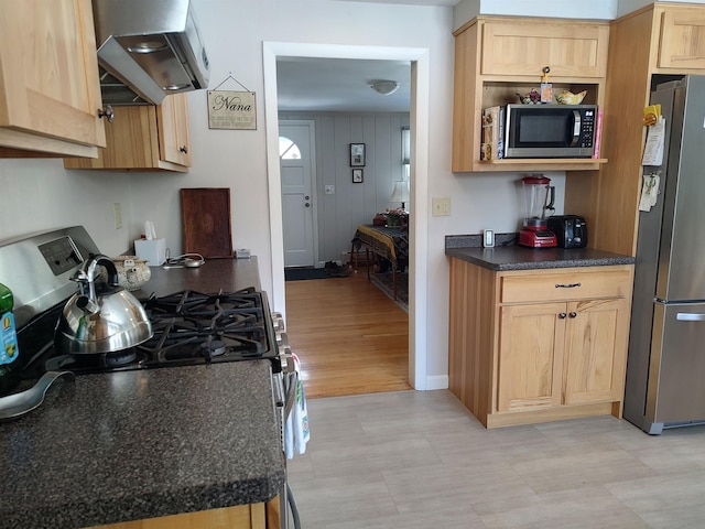 kitchen featuring dark countertops, exhaust hood, light brown cabinets, and appliances with stainless steel finishes