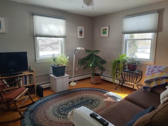 living area featuring plenty of natural light, wood finished floors, and baseboard heating