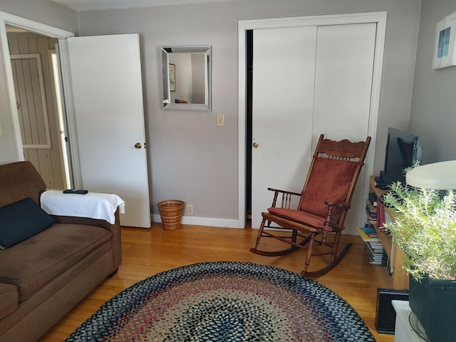 sitting room with baseboards and light wood finished floors