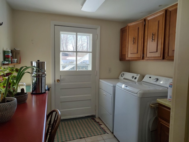 clothes washing area with cabinet space, light tile patterned floors, and independent washer and dryer