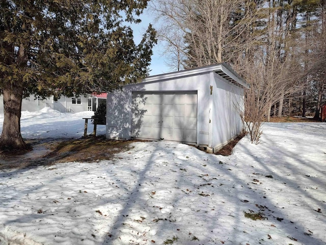 snow covered garage featuring a garage