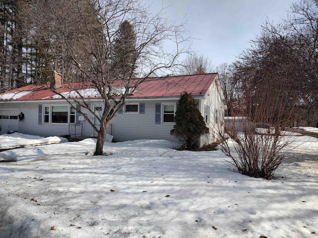 view of front facade with an attached garage and a chimney