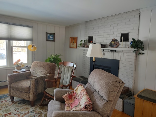 living area with a brick fireplace, wood finished floors, and baseboard heating