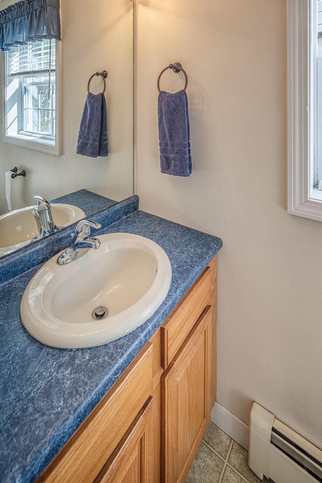 bathroom featuring a baseboard heating unit, baseboards, vanity, and tile patterned flooring