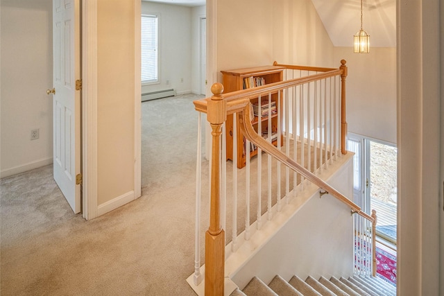 stairs featuring a baseboard heating unit, carpet floors, and baseboards