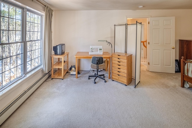 home office with a baseboard heating unit, a healthy amount of sunlight, and light carpet