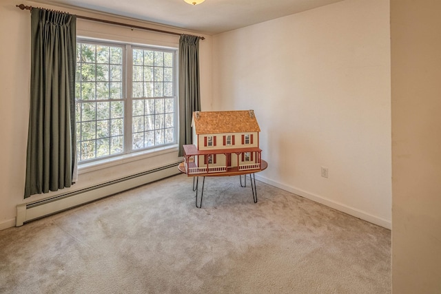 sitting room with baseboard heating, carpet flooring, baseboards, and a healthy amount of sunlight