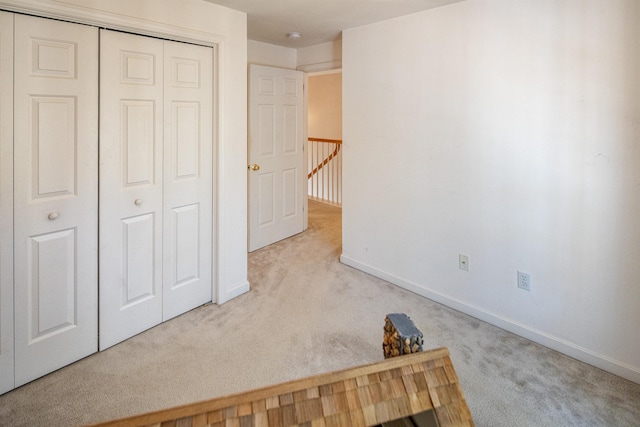 unfurnished bedroom with a closet, baseboards, and carpet floors