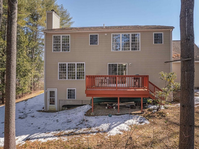 rear view of house with a wooden deck and a chimney