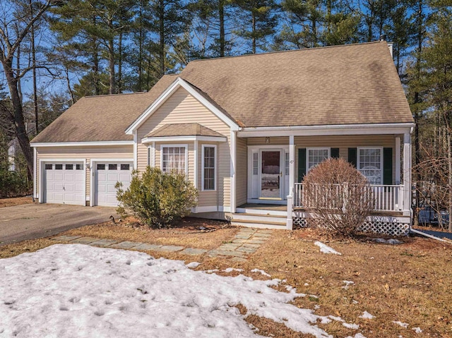 view of front facade with a shingled roof, a porch, an attached garage, and concrete driveway