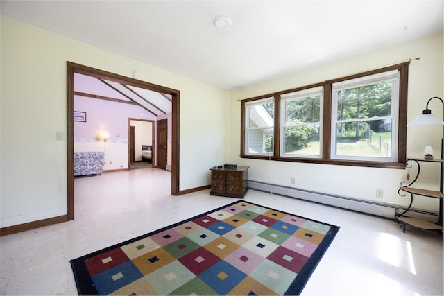 interior space with a baseboard heating unit, lofted ceiling, and baseboards