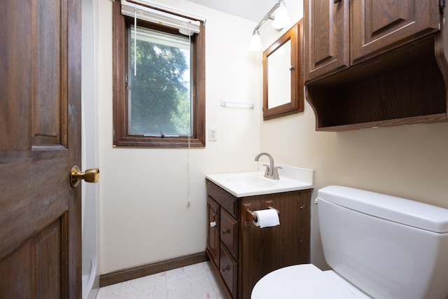 bathroom featuring vanity, toilet, and baseboards