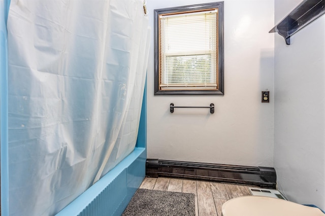 bathroom featuring visible vents, wood tiled floor, toilet, baseboard heating, and shower / bath combination with curtain