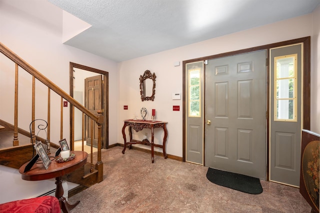 foyer featuring a wealth of natural light, stairway, and baseboards