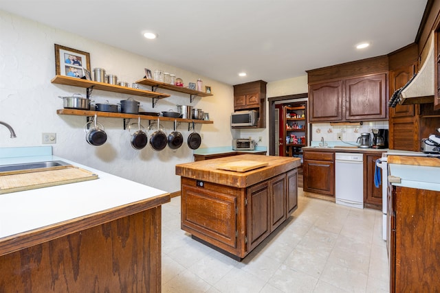 kitchen featuring white appliances, open shelves, a toaster, a sink, and butcher block counters