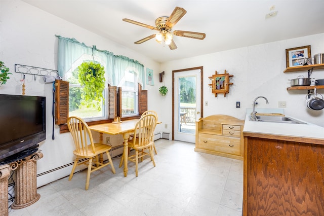 dining room with light floors, baseboard heating, and a ceiling fan