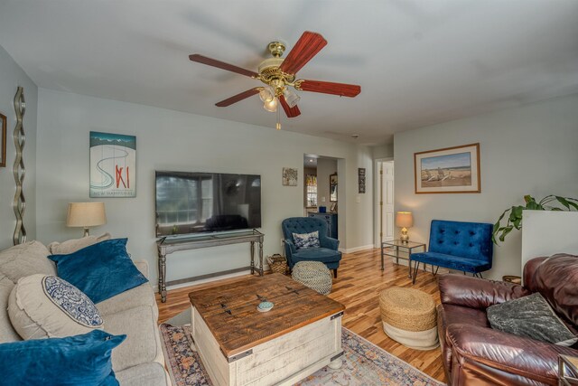 living area with wood finished floors and ceiling fan