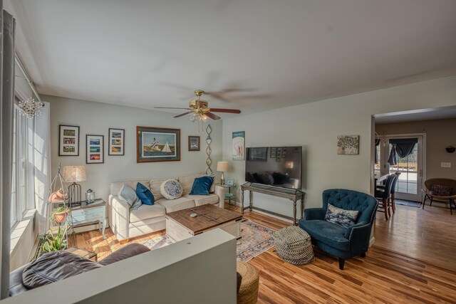 living area with wood finished floors and a ceiling fan