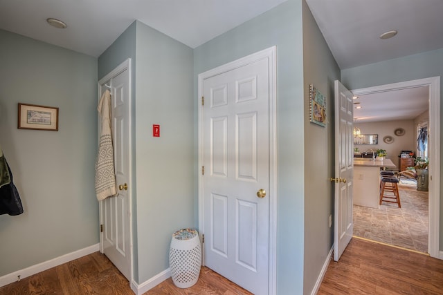 corridor featuring baseboards and wood finished floors